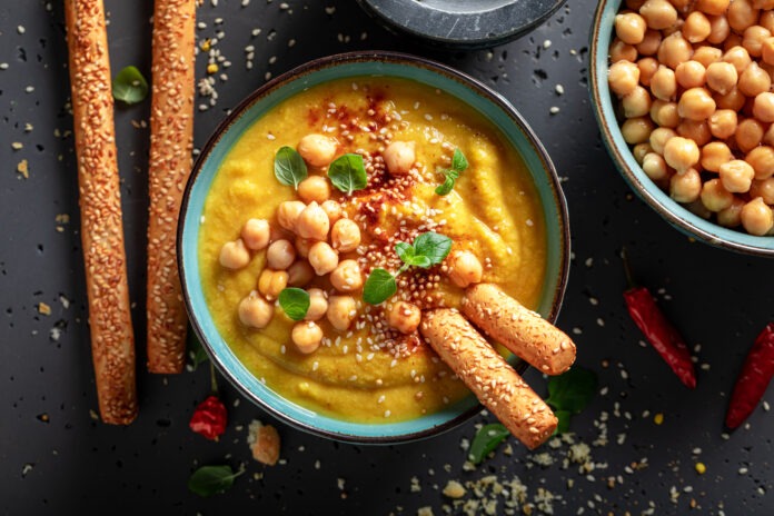 Healthy chickpea soup with grissini and sesame seeds.