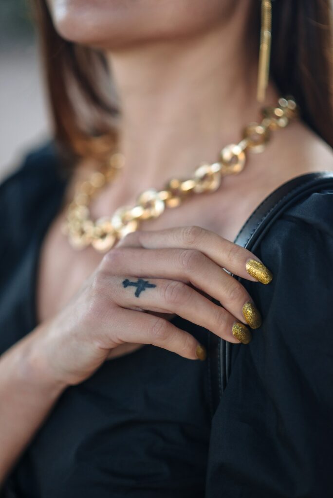 A woman's hand with a beautiful manicure with a tattoo of an airplane on her finger