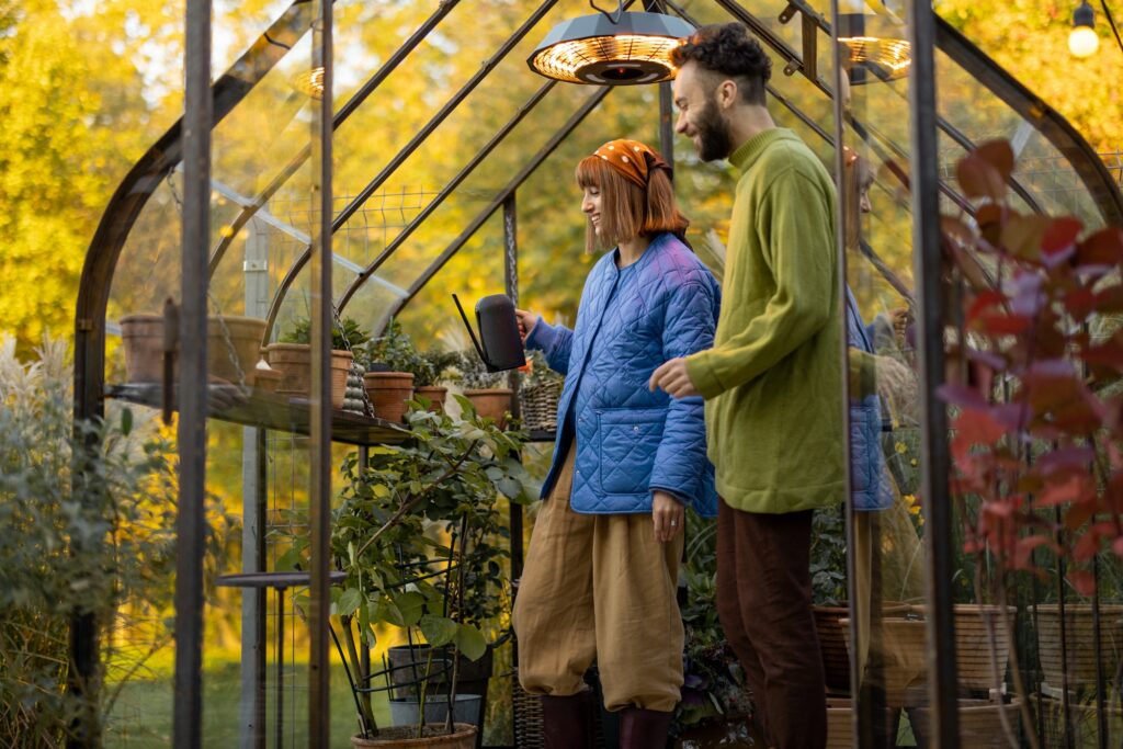 Couple take care of plants in small orangery