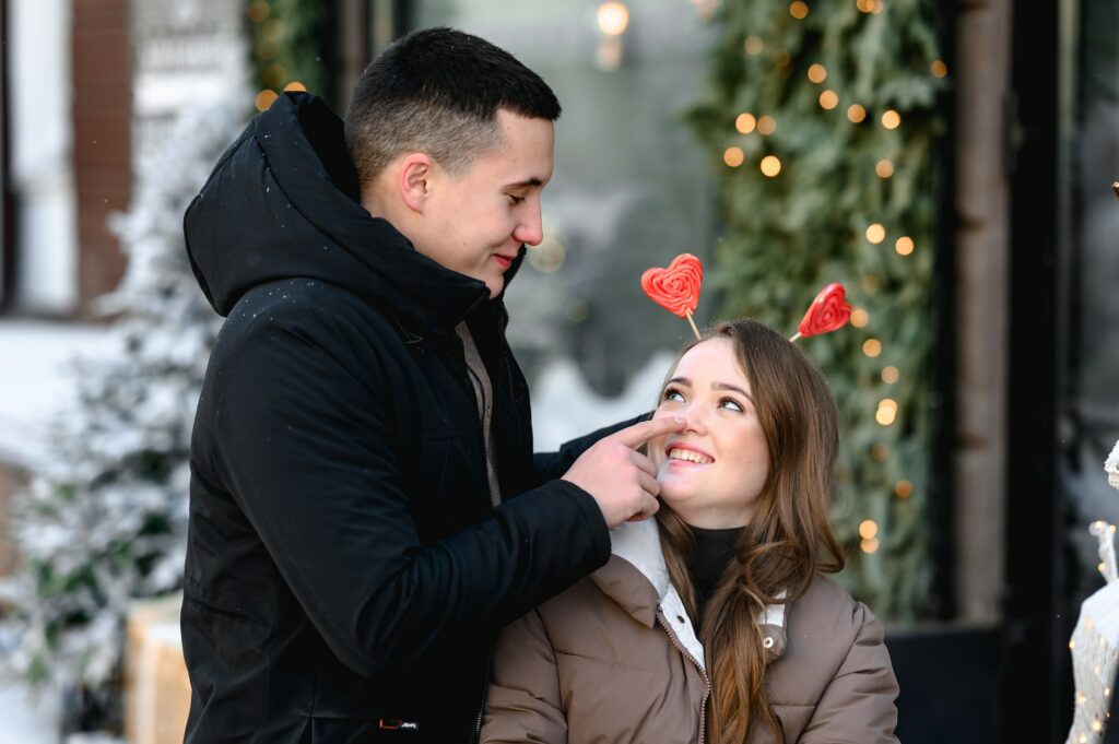 Valentine's Day. young couple in love hold valentines heart-shaped lollipops in their hands.