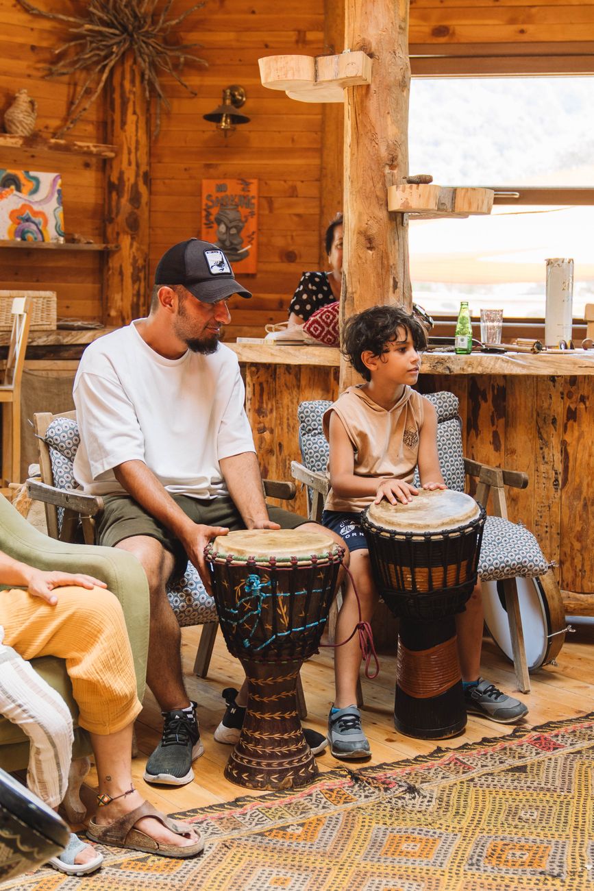 man and boy sitting with drums