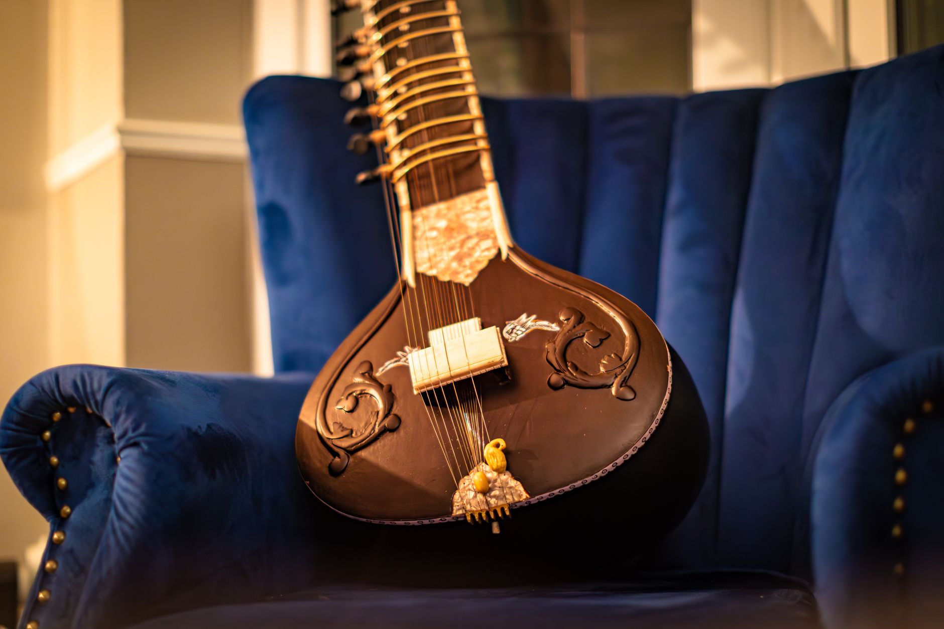 exquisite sitar on blue velvet chair indoors