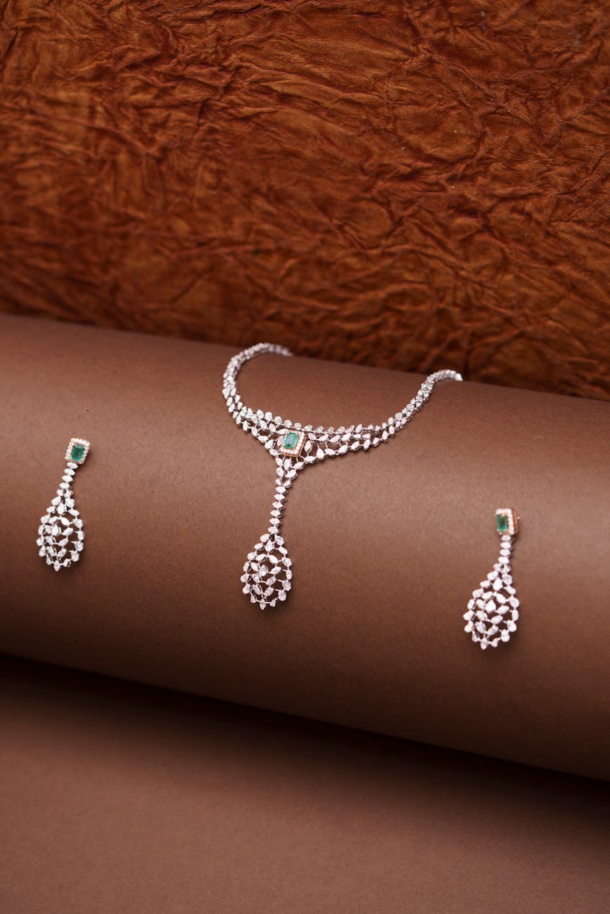 Why Ethical Diamond Engagement Rings Reflect a New Kind of Commitment elegant diamond necklace and earrings on brown backdrop